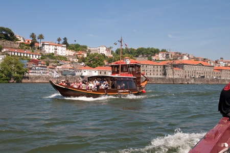 Porto, Portugal - May 14, 2011: Changed Rabelo ship carrying tourists between the bridges of the river Douro showing the riverside area of ââPorto and Vila Nova de Gaia.のeditorial素材