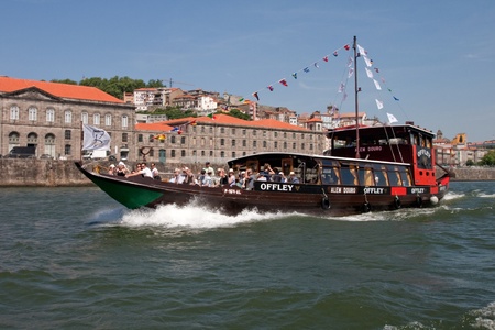 Porto, Portugal - May 14, 2011: Changed Rabelo ship carrying tourists between the bridges of the river Douro showing the riverside area of ââPorto and Vila Nova de Gaia.のeditorial素材