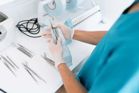 Dentist assistant sterilizing and packing dentist equipment in plastic sterilization pouchesの写真素材