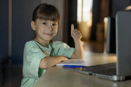 Distance learning education. Happy girl learn english language online with laptop at home. Little...