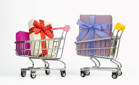 Colorful wrapped boxes in trolley carts on white background. Annual sale shopping season conceptの写真素材