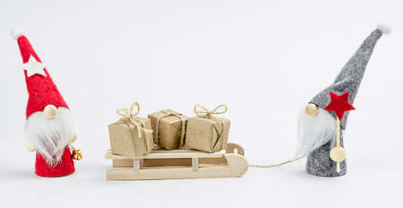 Winter gnomes with homemade christmas gifts on wooden sledの写真素材