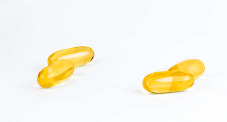 Close up golden color oil supplement in soft gel capsules, healthy product concept