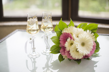 Bouquet of white flowers in a vase, candles and champagne on a copper tray vintage, wedding home decorの写真素材
