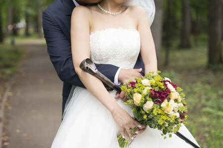 Elegant bride and groom posing together outdoors on a wedding dayの写真素材