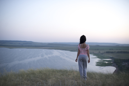 Beautiful young woman standing on the beach. Fashion in Natureの写真素材