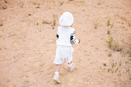 Little girl pick up flowers in the sand careerの写真素材