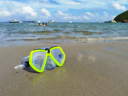 mask for diving lies on the sand, the shore against the background of the wave. High quality photoの写真素材