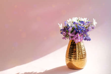 wildflowers in a golden vase on a pink background with bokehの写真素材