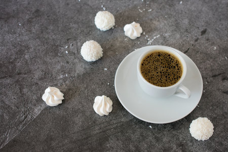 Cup of coffee with marshmallows on a gray background.