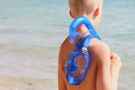 Boys holding snorkeling mask and prepare to dive in .Kid on the beach in front of the sea. active summer holiday vacationの写真素材