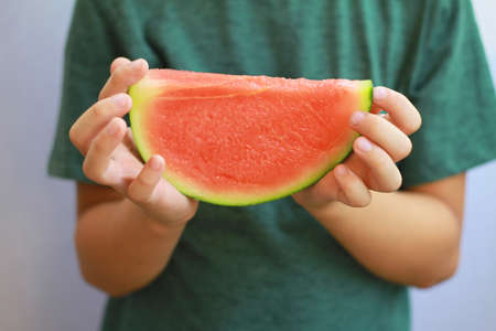 Close up on  Child's hands holding  watermelon. Selective focus imageの写真素材