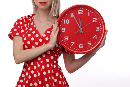 Attractive woman wearing vintage dress holding holding a clock. It's time conceptの写真素材