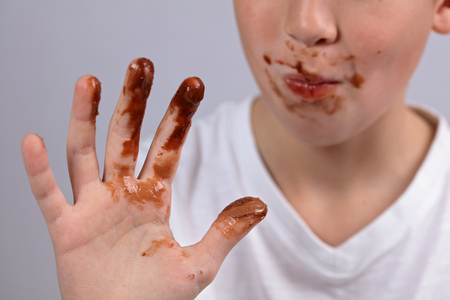Child showing dirty hands with stains of chocolateの写真素材