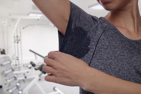 Sport woman armpit sweating. Transpiration stain. Hyperthyroidism conceptの写真素材