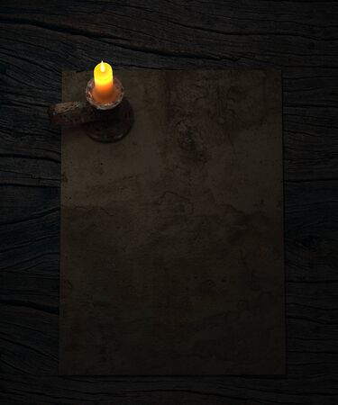 Background with old paper and candle on rustic wooden table.の写真素材