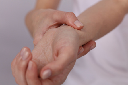 Woman hands checking heart rate pulse on wrist close upの写真素材