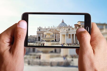 Male hand taking photo of st peter basilica in Vatican with cell, mobile phone. Europe travell, Italian holiday.の写真素材