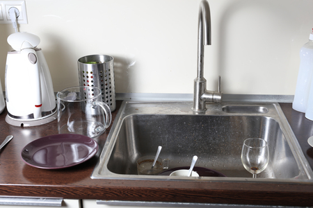 Dirty dishes in a kitchen sinkの写真素材