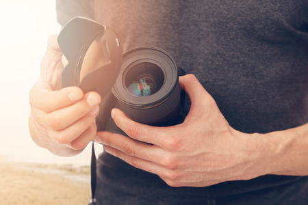 Professional Photographer. Man holding Professional Digital Camera outdoorsの写真素材