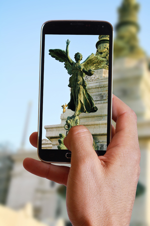 Male hand taking photo of statue in Italian government building in Rome  with cell, mobile phone. Europe travell, Italian holiday.の写真素材