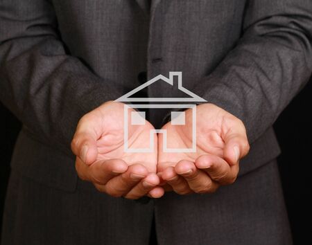 Businessman holding model of a house in his hands. Real-estate insurance conceptの写真素材