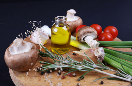 Cooking, Healthy eating concept. Olive oil, herbs, spices, mushrooms. Fresh, raw, organic vegetables on black background.の写真素材