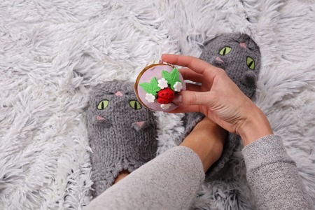 Woman enjoying cold winter day at home, wearing cozy warm wool socks, eating cupcake. Warmth concept.の写真素材