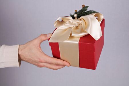 Man holding red present with white Ribbon close up on hand. Gift box. , New year, Christmas concept.の写真素材