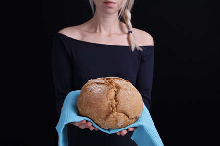 Bread baking, woman holding loaf of tasty fresh breadの写真素材