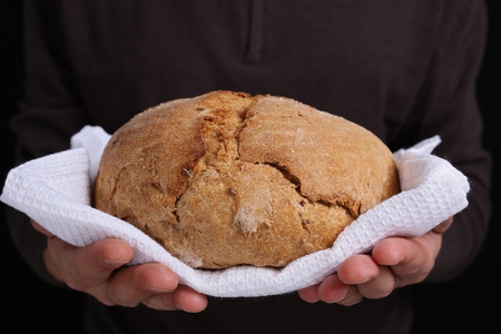 Man holding loaf of tasty fresh bread close upの写真素材