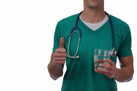 Doctor holding thumbs up and glass of water close up. Importance of drinking water. Isolated on whiteの写真素材