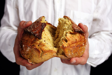 Bread baking, Man eating tasty fresh whole grain gluten free breadの写真素材