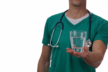Doctor holding glass of water close up. Importance of drinking water. Isolated on whiteの写真素材