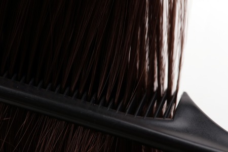 Brown hair and comb on white background. Hairdresser salon concept, Hairdressing Set. Haircut accessories.の写真素材