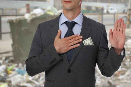 Corrupted politician in front of dirty town. Law and corruption concept.の写真素材