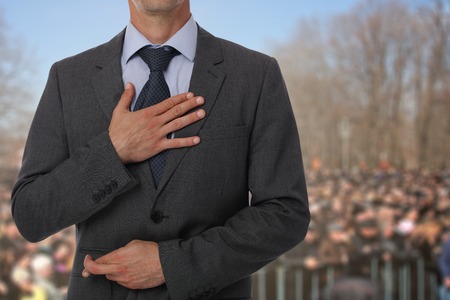 Politician liar gives people impossible promises with fingers crossed on his back.の写真素材