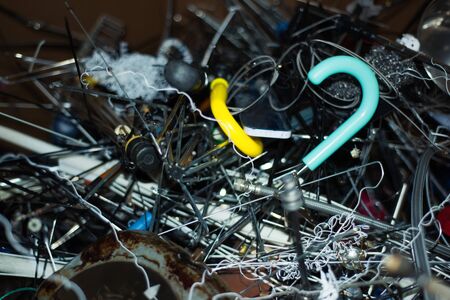 Waste heap from metal parts of broken umbrellas and other metal on waste sorting station. Colorful blurry background from components. Concept of eco, sorting, recycling and disposal of garbage.の写真素材