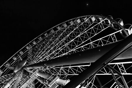 Black and white picture of ferris wheel in nighttime with beautiful backlight. Bottom view on famous Budapest, Hungary, attraction ferris wheel in night. Design pattern. Abstractionの写真素材
