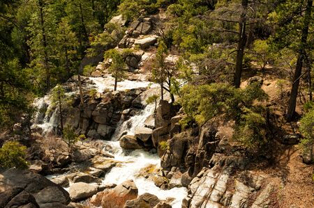 Scenic early spring landscapes with small waterfalls and rocks around in Yosemite National Park, Yosemite, California, USA. Mountain river full of water. Travel destination Yosemite, CA.の写真素材
