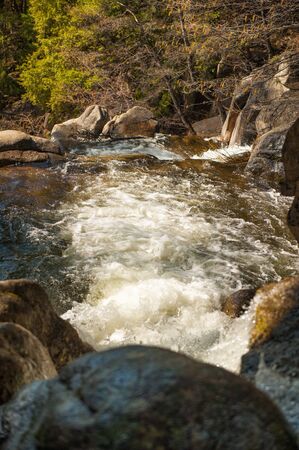 Vertical scenic early spring landscapes with small waterfalls and rocks around in Yosemite National Park, Yosemite, California, USA. Mountain river full of water. Travel destination Yosemite, CA.の写真素材