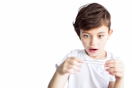 Isolated on white portrait of scared frightened child with thermometer in hands. Worldwide epidemic of coronavirus covid-2019. Health and medical care. Quarantine. Insurance.の写真素材