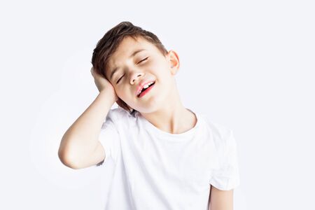 Closeup portrait of sad child with headache holding his head with hand isolated on white background. Worldwide epidemic of coronavirus covid-2019. Health and medical care. Quarantine. Insuranceの写真素材