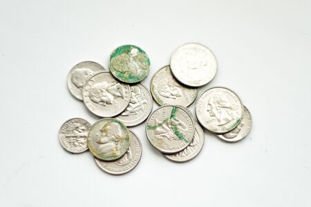 Collection of old american coins, shot close up against white background. Last money with green oxide from piggy bank. Concept photo. Financial crisis because of pandemic coronavirus.の写真素材