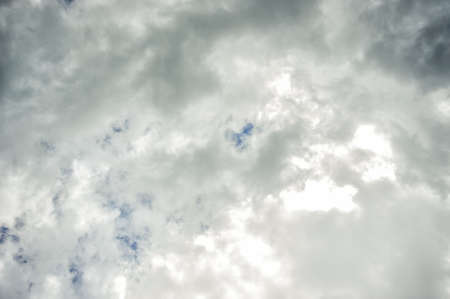 Dark ominous clouds with small pieces of blue sky. Dramatic sky background.