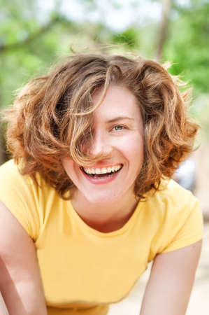 Vertical natural portrait of happy smiling curly 25 years old girl without make-up. Healthy skin. Summer happiness.の写真素材