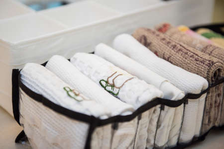 Home storage system for linen, clothes and fabrics. Drawer of cabinet is divided into compartments using boxes. Organizer for underwear and towels. Organizational space - management of environment.の写真素材