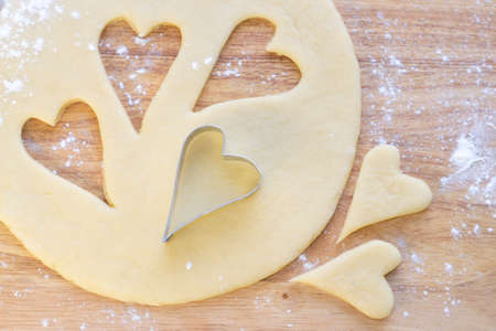 Hearts shaped cookie cutter on raw cookie dough  Closeup  の写真素材