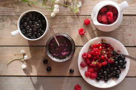 Fresh berries and jam on wooden table
