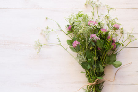 Bouquet of wild flowers pn white wooden backgroundの写真素材